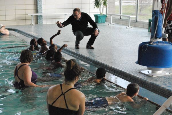 young swimmers giving Bank President high fives poolside